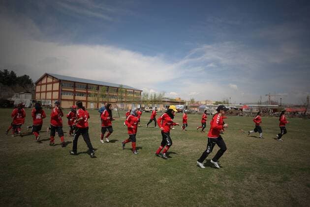 Players of Afghan women s national soccer team warm up before a friendly match against NATO-led International Security Aid Force women s soccer team in Kabul, capital of Afghanistan, on April 1, 2011. The match ended with a 0-0 tie.  o0 Totale Sportstätte Fußballplatz