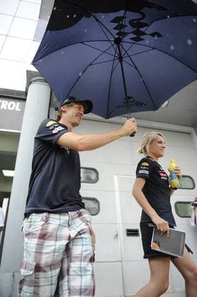 Sebastian VETTEL (GER),Red Bull Racing ,Einzelbild,angeschnittenes Einzelmotiv,Halbfigur,halbe Figur,geht mit einem Regenschirm während des täglichen Regenschauers durch das Fahrerlager,Paddock und schützt seine Pressesprecherin Britta Röske. Formel 1:GP von Malaysia Sepang Circuit Kuala Lumpur,Saison2011,