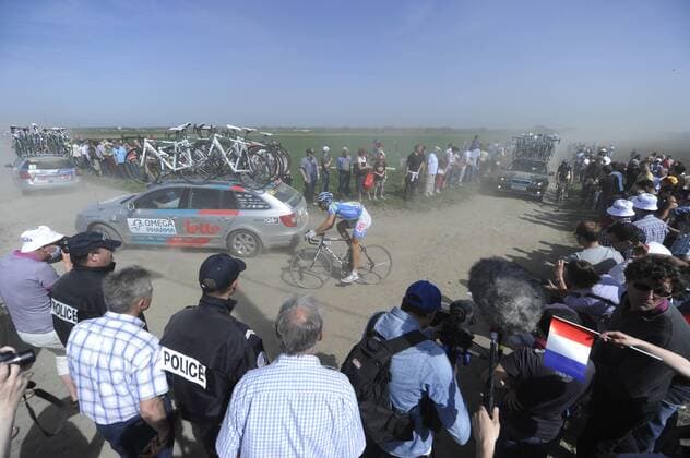 Radrennen Paris Roubaix am 10.04.2011 an der 17. Kopfsteinpflaster Passage bei Haveluy. Abgehängte Fahrer Kämpfen sich durch die Autos zurück ins Feld. o0 Zuschauer Fans