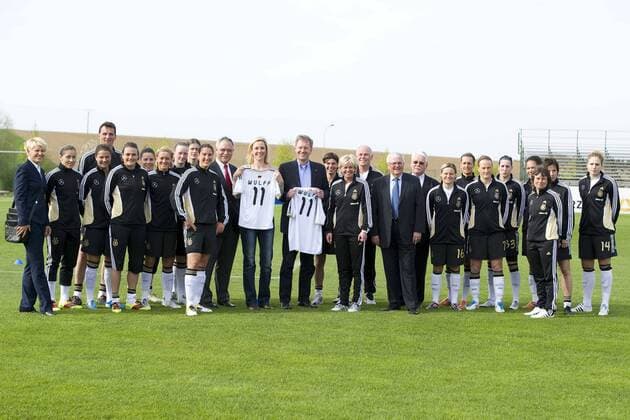 Bundespräsident Christian WULFF (GER, Mitte) mit Ehefrau Bettina WULFF, beide mit Trikot neben: Bundestrainerin Silvia NEID (GER, 12.v.re.) und Dr. DFB Präsident Theo ZWANZIGER (GER, 10.v.re.) vor der Deutschen Frauen Nationalmannschaft, Besuch des Trainings der Frauen-Nationalmannschaft am 11.04.2011 in Bitburg, o0 Frauenfußball Nationalteam Partnerin, Frau, Ehefrau Familie Trainer Nationaltrainer Funktionär