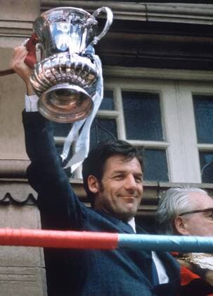John Lyall (West Ham Manager) holds aloft the FA Cup trophy to the fans at the Town Hall. West Ham homing. The day after the FA Cup Final. West ham United v Fulham. 1975.  Objekte Pokal Pokalsieg Sieg Finale Pokalfinale England 1974