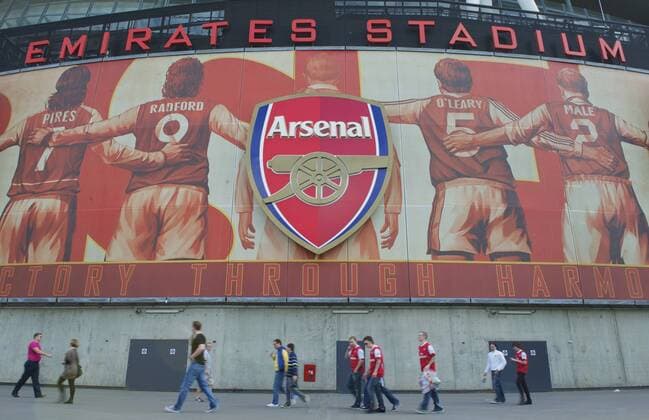 Football: FA Premier League, 2010 2011, FC Arsenal London; Supporters mill around Arsenal s Emirates Satdium before the Premiership match against Liverpool. xHOCHxZWEIx xPropagandax  o0 Fan, Fußballfan, Publikum Schriftzug totale victory through harmony