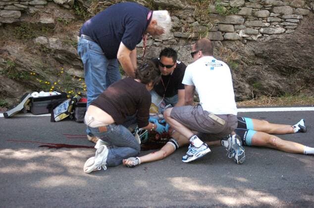 Wouter Weylandt (Leopard Trek) wird nach seinem schweren Sturz auf der Abfahrt am Passo del Bocco medizinisch versorgt - der belgische Radprofi erlitt einen tödlichen Schädelbasisbruch --- Giro d Italia, 3. Etappe: Reggio Emilia - Rapallo  o0 Unfall Unglück Todesfall Blut blutig Sanitäter Erste Hilfe medizinische Versorgung Kopfverletzung