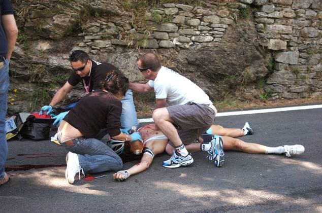 Wouter Weylandt (Leopard Trek) wird nach seinem schweren Sturz auf der Abfahrt am Passo del Bocco medizinisch versorgt - der belgische Radprofi erlitt einen tödlichen Schädelbasisbruch --- Giro d Italia, 3. Etappe: Reggio Emilia - Rapallo  o0 Unfall Unglück Todesfall Blut blutig Sanitäter Erste Hilfe medizinische Versorgung Kopfverletzung