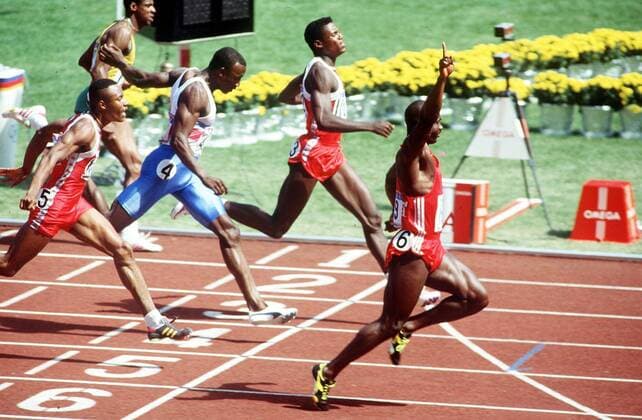 BEN JOHNSON (CANADA) RAISES HIS ARM IN TRIUMPH AFTER WINNING THE 100M in front of Carl Lewis and Linford Christie . 1988 OLYMPICS.  o0 Olympiasieg Sieg o0 Leichtathletik