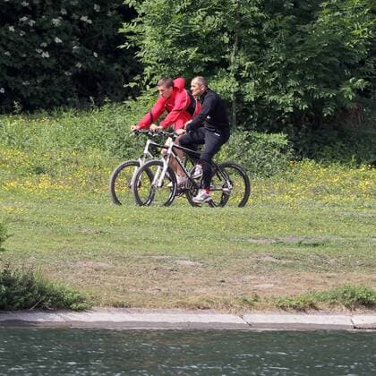 1.FC Köln Lukas Podolski hält sich fit für die Nationalmannschaft Runde mit dem Fahrrad um den Decksteiner Weiher Lukas Podolski mit Willi Breuer
