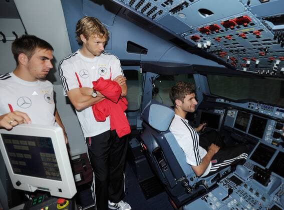 Thomas MUELLER (Deutschland) sitzt im Cockpit des Flugsimulator des Airbus A-380. Links: Kapitän Spielführer Mannschaftskapitän Philipp LAHM (Deutschland) und Simon ROLFES (Deutschland). Die deutsche Fussball-Nationalmannschaft beim Lufthansa Flight Training Center am Flughafen Frankfurt. Fussball: Vorbereitung der deutschen Fussball Nationalmannschaft der Männer in Frankfurt Main, 31.05.2011.