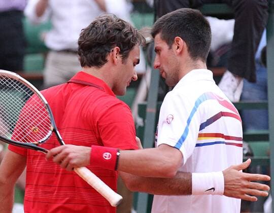 Roger Federer of Switzerland (L) meets Serbian Novak Djokovic at the net after Federer won their French Open mens semifinal match at Roland Garros in Paris on June 3, 2011.  PAR20110603733