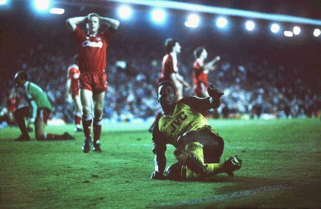Michael Thomas (Arsenal FC) celebrates scoring the winning goal by sliding over to the Arsenal FC Fans, as Steve Nicol holds his hands to his head. Liverpool FC v Arsenal FC; 26 05 1989; Anfield Football 