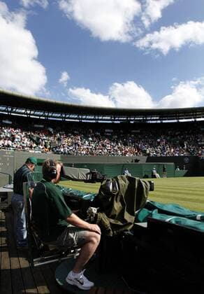 Wimbledon Championships 2011, AELTC, London, ITF Grand Slam Tennis Tournament . TV Kameramann sitzt am Spielfeldrand auf Court 1,Fernsehen,Uebertragung,Hochformat o0 TV Medien Kamera Fernsehkamera