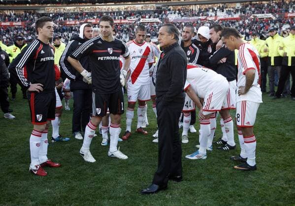 BUENOS AIRES, - River Plate s team coach Juan Jose Lopez (C) and his players are protected by the policemen after their Argentina s first division second leg playoff soccer match in Buenos Aires, capital of Argentina, June 26, 2011. River Plate, the giant Argentine league club, suffered their biggest humiliation ever with relegation to the second division for the first time in the first leg of their play-off on Wednesday and tying 1-1 in the second leg match on Sunday. --- 