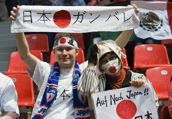 japanische Fans mit Spruchbaendern und Mundschutz, allgemein, Feature, Vorrunde, Spiel 11, Gruppe B, am 01.07.2011 in Leverkusen Fussball Frauen Weltmeisterschaft 2011 vom 26.06. - 17.07.2011