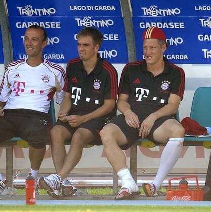 09.07.2011, Fußball 1.Bundesliga, Trainingslager FC Bayern München in Arco (Trentino, Gardasee), Testspiel FC Bayern München - Nationalmannschaft Katar. Bastian Schweinsteiger (re, München) pausiert verletzungsbedingt und sitzt mit Mütze und Verban am rechten Fußgelenk auf der Bank. v.li: Thomas Wilhelmi, Philipp Lahm (Bayern München), Bastian Schweinsteiger.