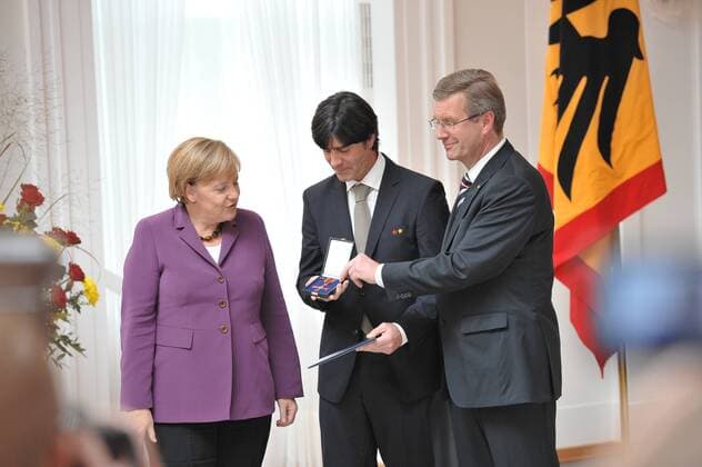 Bild: Bundespräsident Christian WULFF rechts und Bundestrainer Joachim LOEW mitte und Bundeskanzlerin Angela MERKEL links bei der Verleihung des silbernen Lorbeerblattes an die Deutsche Nationalmannschaft der Herren bei der WM 2010 und die Verleihung des Verdienstordens der Bundesrepublik Deutschland an den Bundestrainer Joachim Löw im Schloss Bellevue am 05.10.2010 durch den Bundespräsidenten Christian Wulff sowie der Bundeskanzlerin Angela Merkel.