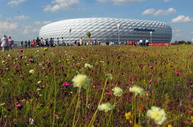 MUENCHEN,DEUTSCHLAND,26.JUL.11 - FUSSBALL - Audi Cup 2011, FC Bayern München. Bild zeigt Fans und die Allianz-Arena, Heimspielstätte des FC Bayern München.  o0 Fan totale Sportstätte o00 Aufmacher Blumen Wiese Gras Idylle Frühling Natur Sommer