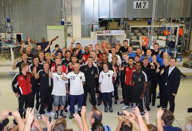 Die Spieler der Nationalmannschaft bei einem Gruppenbild im Werk, mit Mitarbeitern von Mercedes-Benz. Werksführung der deutschen Fussball Nationalmannschaft im Motorenwerk von Mercedes-Benz in Bad Cannstatt Stuttgart am 9.8.2011. o00 Wirtschaft
