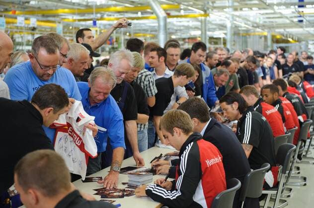 Die Spieler der Nationalmannschaft geben den Arbeitern Autogramme im Werk. Im Vordergrund: Philipp LAHM (Deutschland). Fussball: Werksfuehrung der deutschen Fussball- Nationalmannschaft der Maenner am 09.08.2011 im Motorenwerk Bad Cannstatt, Stuttgart, 09.08.2011 