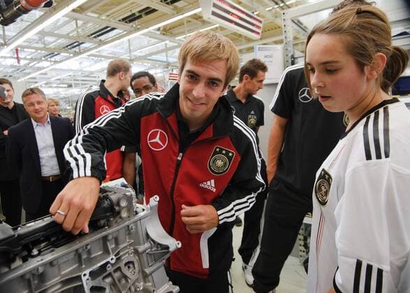 Eine Mitarbeiterin von Mercerdes-Benz zeigt den Spielern der Nationalmannschaft ihre Arbeit am Band. Philipp LAHM (Deutschland) legt Hand an. Fussball: Werksfuehrung der deutschen Fussball- Nationalmannschaft der Maenner am 09.08.2011 im Motorenwerk Bad Cannstatt, Stuttgart, 09.08.2011  o00 Wirtschaft Fan