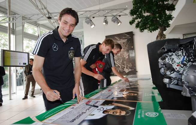 Die Spieler der Nationalmannschaft geben Autogramme, signieren Poster zum Laenderspiel Deutschland - Brasilien. Christian TRAESCH (Deutschland), Holger BADSTUBER (Deutschland), Bastian SCHWEINSTEIGER (Deutschland). Fussball: Werksfuehrung der deutschen Fussball- Nationalmannschaft der Maenner am 09.08.2011 im Motorenwerk Bad Cannstatt, Stuttgart, 09.08.2011 
