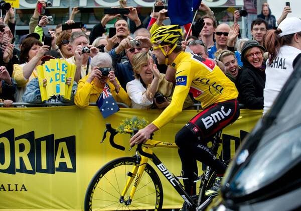 Riding in his winner s yellow jersey, Tour de France winner Cadel Evans of Australia is greeted by some of the thousands of fans which lined the streets for his homecoming victory parade in Melbourne, Australia - 