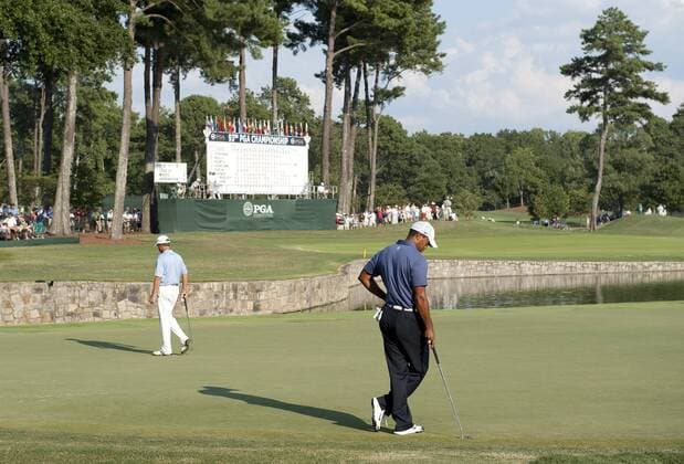 Tiger Woods (R) stands on the 18th green as Davis Love III lines up his putt during the second round of the 93rd PGA Golf Herren Championship at the Atlanta Athletic Club on August 12, 2011 in Johns Creek, Georgia.  BKX2011081262