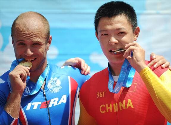Gold medalist Denis Dmitriev (L) of Russia and bronze medalist Zhang Miao of China pose for photos during the awarding ceremony of men s sprint of cycling track at the 26th Summer Universiade in Shenzhen, a city of south China s Guangdong Province, on Aug. 18, 2011. (Xinhua Li Ga)(wx) CHINA-SHENZHEN-UNIVERSIADE-CYCLING TRACK-MEN S SPRINT (CN) 