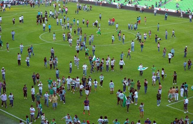 Fans run to the field after hearing a gunfight outside the Corona s stadium, in Torreon, northern Mexico, on Aug. 20, 2011. The Mexican first division match between Santos and Morelia was suspended after an armed group attacked a police patrol outside the stadium, authorities said -  o00 Gesellschaft