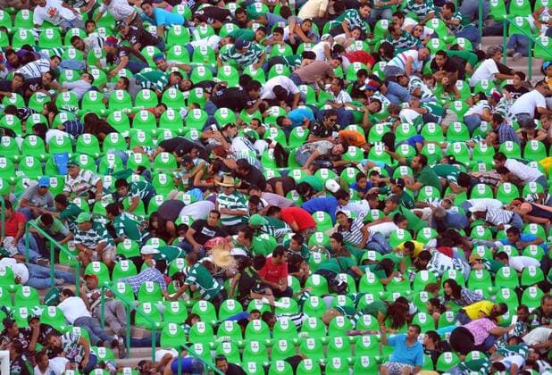 Fans protect themselves after hearing a gunfight outside the Corona s stadium, in Torreon, northern Mexico, on Aug. 20, 2011. The Mexican first division match between Santos and Morelia was suspended after an armed group attacked a police patrol outside the stadium, authorities said -  o00 Gesellschaft