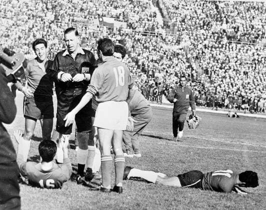 Santiago: fights broke out during opening minutes of the World Cup Match between Italy and Chile . After second incident , English referee Ashton (second Left) ordered Italian forward Ferrini off the field when he fouled Chilean player Sanchez who lies dazed on the pitch. Teammates David (no18 )and Robotte argue with referee . 2nd June 1962 UnitedArchives1179320
