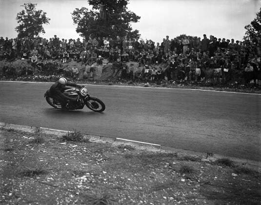 The winner once again and unbeaten at Brands Hatch in three years , John Surtees , winning on his Norton motorbike after beating Geoff Duke once again . 1955 UnitedArchives1246706