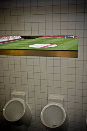Die Mercedes Benz Arena brilliert durch innovative Konzepte. Hier Kann der Anhänger des VFB Stuttgart sich erleichtern ohne dabei etwas vom Geschehen auf dem Spielfeld zu verpassen. o0 Sportstätte Stadion WC Toilette Perspektive Durchblick Pissoir kurios Komik