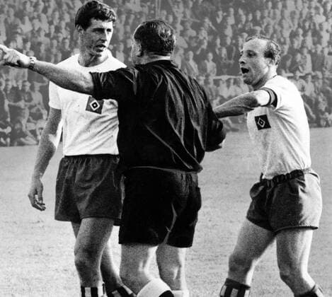 Jürgen Kurbjuhn (li.) und Uwe Seeler (beide Hamburger SV) beschweren sich bei Schiedsrichter Kurt Handwerker Aufmacher