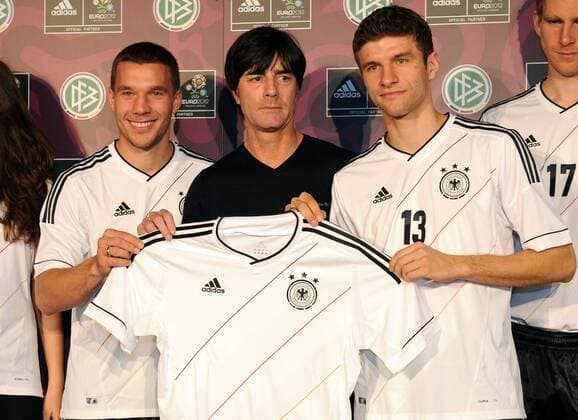 FUSSBALL DEUTSCHE NATIONALMANNSCHAFT SAISON 2011 2012 Lukas PODOLSKI, Trainer Joachim LÖW und Thomas MÜLLER, (v.l., alle Deutschland) präsentieren das neue Trikot der Nationalmannschaft am 09.11.2011 in Hamburg  o0 Vorschau EM Wirtschaft Ausrüster Euro 2012