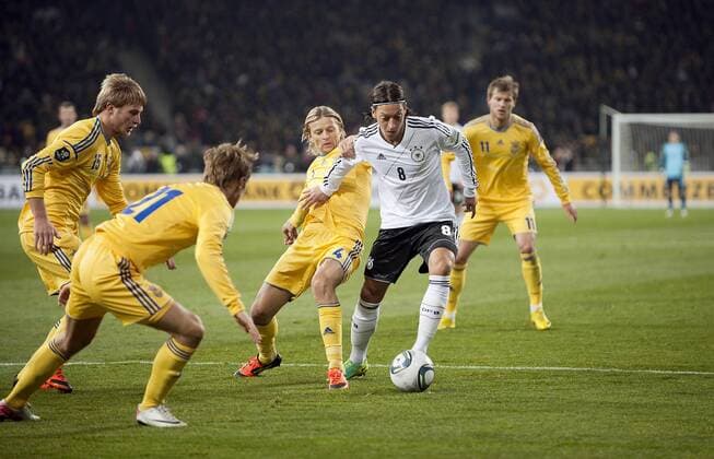 Mesut ÖZIL (, GER), Aktion mit Ball, umzingelt von gegnerischen Spielern, Anatoliy TYMOSCHUK (UKR) versucht ihn festzuhalten; Fussball