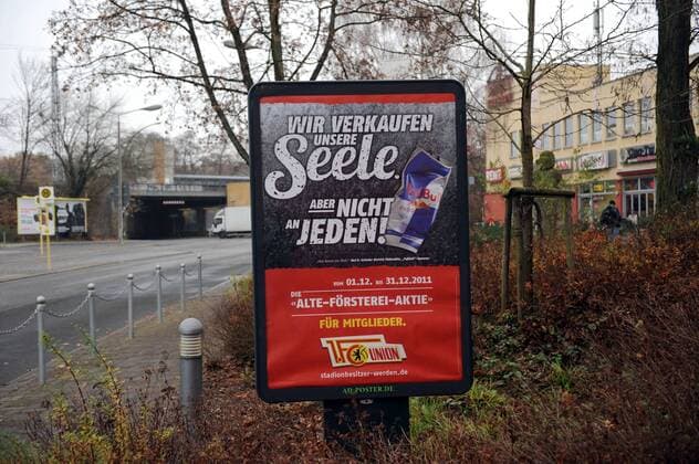 Fussball, Herren, Saison 2011 2012, 2. Bundesliga, 1. FC Union Berlin, Werbung zum Verkauf von Aktien am Stadion An der Alten Försterei, Hier mit einer satirischen Anspielung auf den Getränkehersteller Red Bull, Einkaufszentrum am Bahnhof Grünau (Köpenick) o0 Objekte Parodie Satire Spott Hohn Häme Plakat Werbeplakat Transparent Werbetransparent Ironie