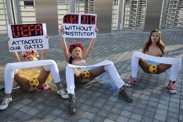 Protest der ukrainischen Frauengruppe FEMEN gegen die geplanten staatlichen Verhaltensvorschriften während der Fussball-Europameisterschaft 2012, vor dem Olympia-Stadion in Kiew, halten Transparente hoch mit Protestparolen, am 02.12.2011 in Kiew Ukraine