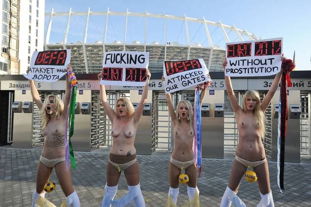 Protest der ukrainischen Frauengruppe FEMEN gegen die geplanten staatlichen Verhaltensvorschriften während der Fussball-Europameisterschaft 2012, vor dem Olympia-Stadion in Kiew, die halbnackten Frauen halten Transparente hoch mit Protestparolen, am 02.12.2011 in Kiew Ukraine