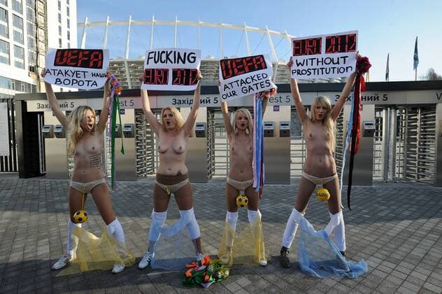 Protest der ukrainischen Frauengruppe FEMEN gegen die geplanten staatlichen Verhaltensvorschriften während der Fussball-Europameisterschaft 2012, vor dem Olympia-Stadion in Kiew, die halbnackten Frauen halten Transparente hoch mit Protestparolen, am 02.12.2011 in Kiew Ukraine