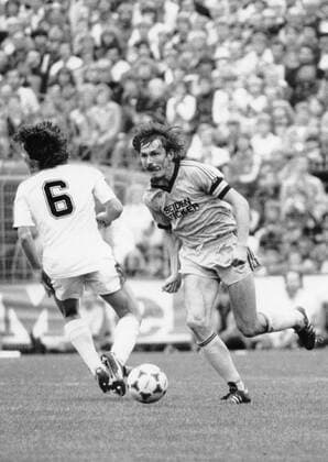 Ewald Lienen (DSC Arminia Bielefeld) 10 82 höck Ewald Lienen (re.) im Zweikampf mit Gladbachs Nationalspieler Lothar Matthäus im Oktober 1982 Deutschland deutsch Deutscher Mann Fußball Verein Fußballverein Fußballclub Bundesliga Fußballmannschaft Elf Team Spieler Fußballspieler Fußballer Sportler adidas Ball Seidensticker Bart Kapitän Kapitänsbinde german soccer football hoch ganz laufend gehend sw draußen