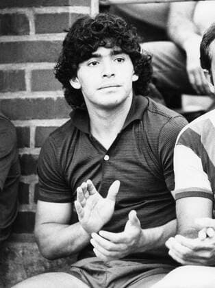 Diego Maradona (Fußballspieler) 08 82 thö Diego Maradona im August 1982 Argentinien argentinischer Argentinier Mann Fußballer Sportler Fußball Trainer Fußballtrainer argentinian soccer football player hoch halb sitzend neutral leger lockig Locken schwarzhaarig klatschend applaudierend gestikulierend Beifall sw
