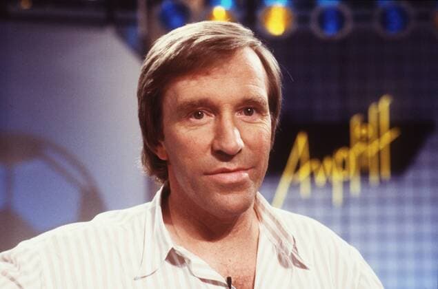 Günter Netzer in Anpfiff 07 88 hör Mann Ex-Fußballspieler ehemaliger Fußballprofi Profispieler Profi Spieler Fußball Experte Fußballexperte Manager TV Fernsehen Moderation Moderator blond kurzhaarig leger Hemd Portrait quer lächelnd Studio Fernsehstudio Kulisse Dekoration Logo