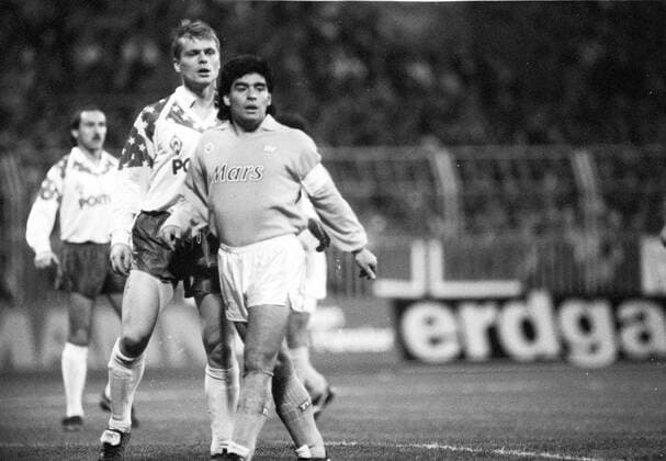 Diego Maradona (ehemaliger Fußballprofi) 12 89 ru Diego Maradona beim UEFA-Cup-Spiel Werder Bremen gegen SSC Neapel im Dezember 1989 Mann Argentinier Argentinien Südamerika Südamerikaner Sportler Fußball-Profi Ex-Fußballer Fußball Fußballer Profi Spieler dunkelhaarig Locken lockig gelockt Sportkleidung Trikot Sporthose kurz Fußballtrikot Mars Geste Gestik gestikulieren gestikulierend laufen laufend festgehalten vom Gegenspieler Foul gefoult Rasen Spielfeld Feld Stadion Mannschaft Mannschaften Seitenlinie Linie Strafraum UEFA Cup Spiel Hochformat hoch ganz sw