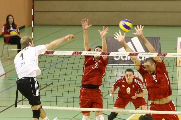 Volleyball DVV-Pokal Männer 2011 12 Halbfinale - Moerser SC vs. VfB Friedrichshafen in Mühlheim: Thomas Jarmoc ( Friedrichshafen ), links - überwindet den Block von - Dirk-Jan van Gendt ( Moers ) und Tim Broshog ( Moers ) - Michael Oliemann ( Moers ), im Hintergrund - beobachtet die Szene