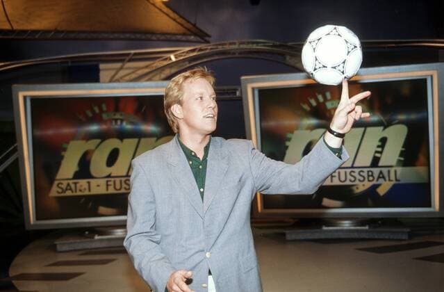 Johannes B. Kerner 09 92 ue Mann Fernsehen Journalismus Show quer halb blond Sakko leger stehend spielend Fußball Studio Logo SAT.1 lächelnd ran Fußballshow TV Show Bundesliga Fernsehstudio Kulisse SAT.1 Moderator Moderation Ball jonglierend Jonglage