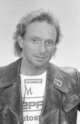 Egon Müller (Motorsportler) 07 89 dar Egon Müller im Juli 1989 Deutschland deutsch Deutscher Mann Motorsport Motocross Rennsport Speedway Speedwayfahrer Fahrer Motorrad Motorradfahrer Motorradsport Sänger Musiker Amadeus Liszt german racing leger Lederjacke Shirt Sticker Werbung Reklame LUK hoch Portrait lächelnd sw