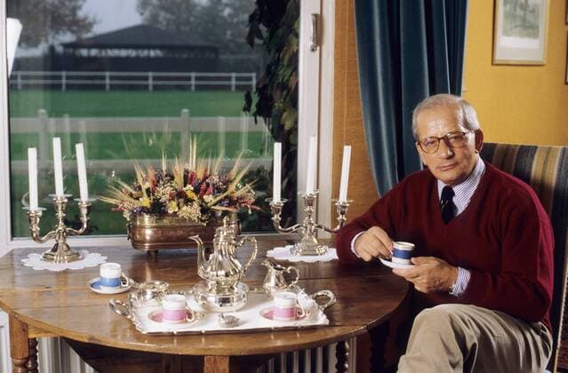 Hans Günther Winkler 11 95 her Mann Reiten Wirtschaft Marketing Brille grauhaarig leger Pullover Krawatte quer halb sitzend Stuhl Tisch Geschirr Kerze Beine neutral Tasse trinkend haltend