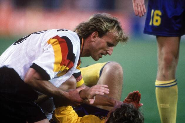 Andreas Brehme (Deutschland, li.) kümmert sich um seinen blutenden Gegenspieler Jan Eriksson (Schweden)