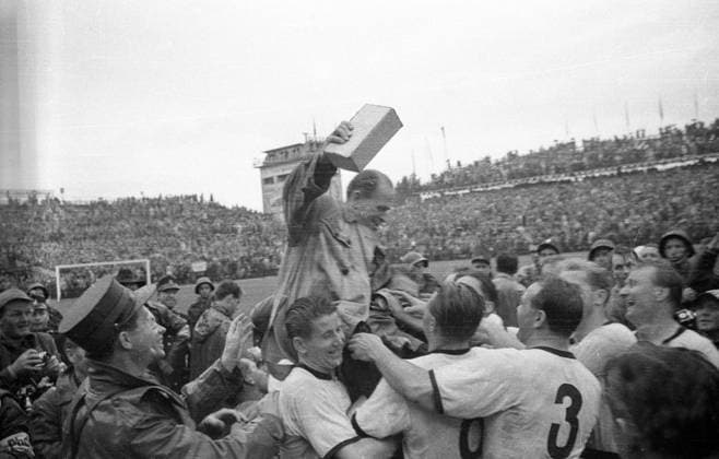 WM Finale 1954 in Bern - Die BR Deutschland wird Weltmeister - Bundestrainer Sepp Herberger (obenauf) jubelt mit Helmut Rahn (li.) und Josef Posipal (re.) sowie mit weiteren seiner Jungs