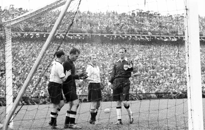 WM Finale 1954 in Bern - BR Deutschland - Ungarn 3:2 - Schiedsrichter William Ling (England, re.), der verletzte Torwart Toni Turek (2.v.li.), Werner Liebrich (2.v.re.) und Werner Kohlmeyer (alle BRD)