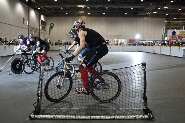 15.01.12 London, England. Players fight for possession whilst the goaltender minds his net during the London International Invitational bike polo bronze medal playoff match at The Bike Show between the Dead Rappers (black shirts) of London and Cosmic (purple shirts) also of London at ExCeL Centre, East London. xDavidxFearn ActionxPlusx  ActionPlus11235028